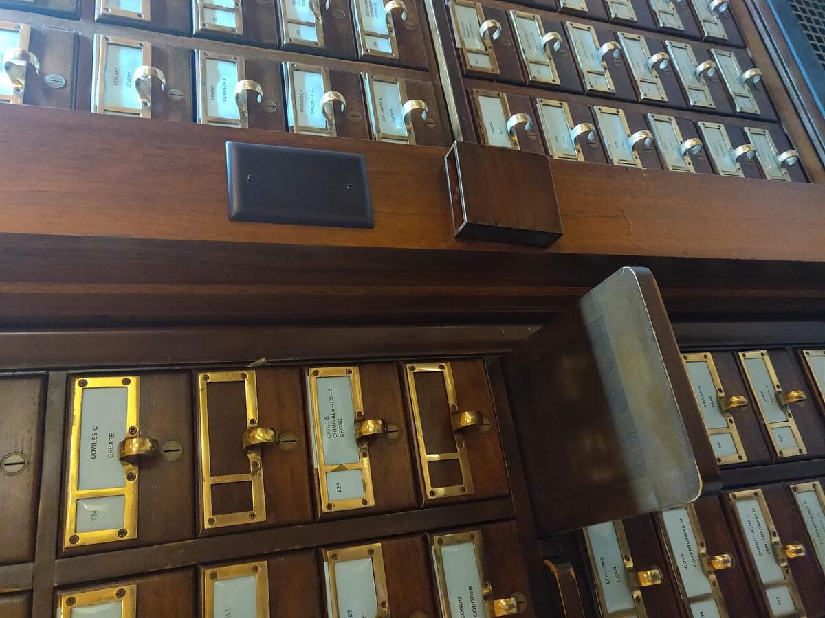 A library card catalog cabinet, the paper-based system researchers used to review related literature before AI literature review generators