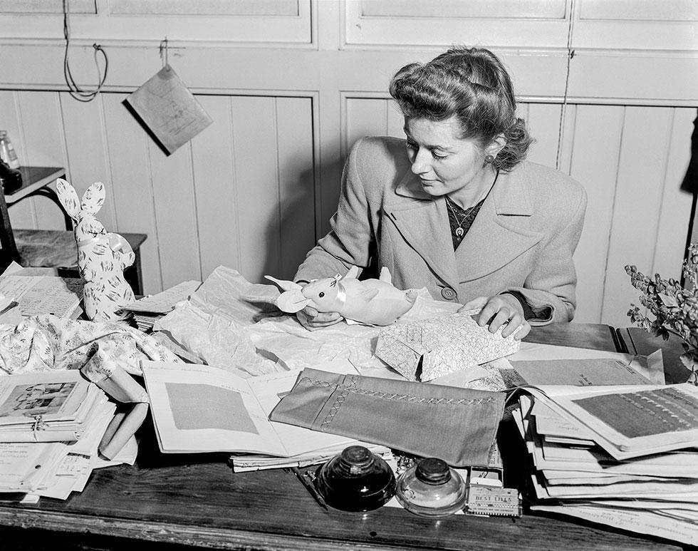 A Blackfriars Correspondence School teacher sorting a stack of mailed student assignments in 1946