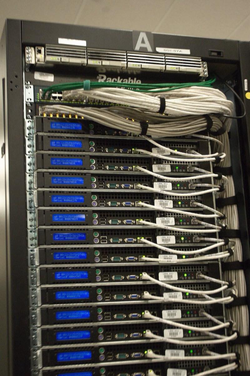 Rear of a data-center rack showing dense white network cabling into rows of servers