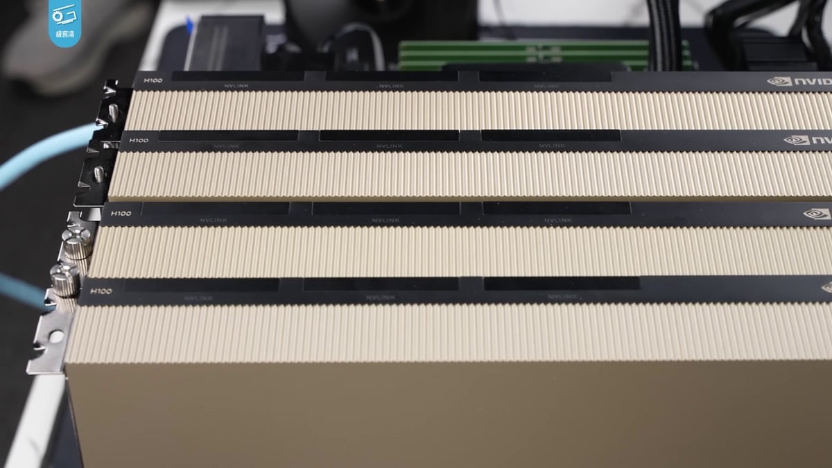 Four NVIDIA H100 accelerator cards side by side with NVLink connectors exposed