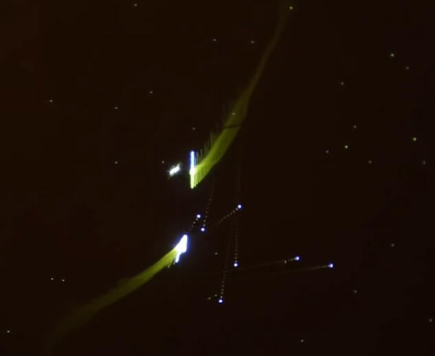 Spacewar! gameplay: two ships trailing exhaust around a central star on a black field of dots