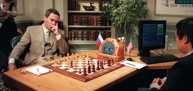 Gary Kasparov sitting in front of a chessboard during a match against IBM's